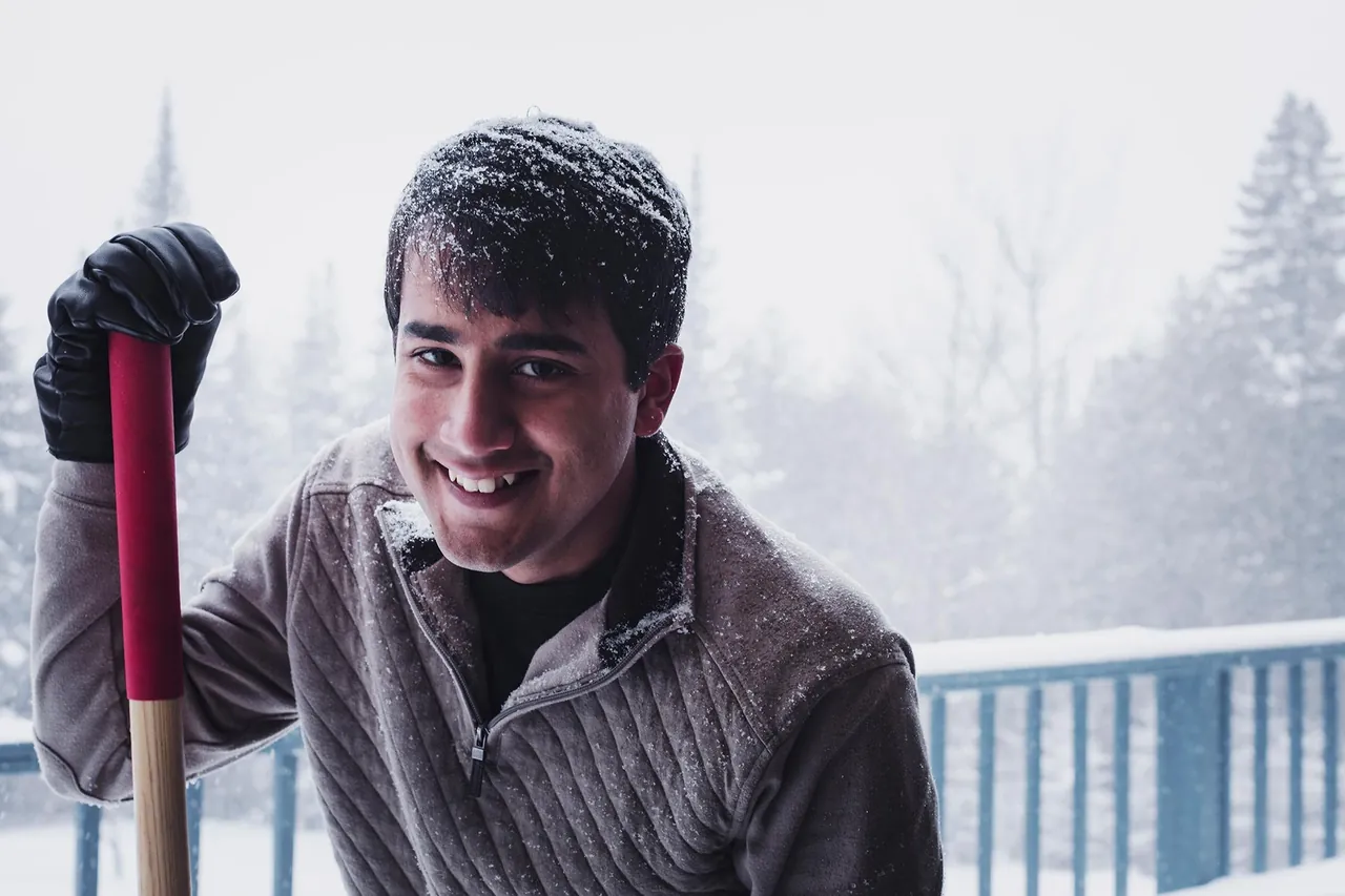 Smiling man with a shovel in the snow