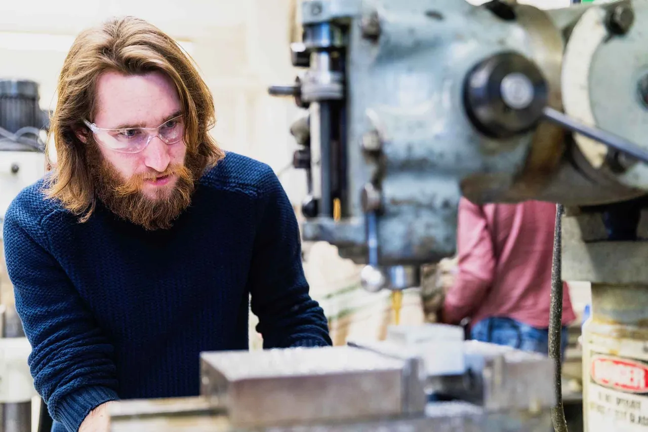 Young man at work in a machine workshop